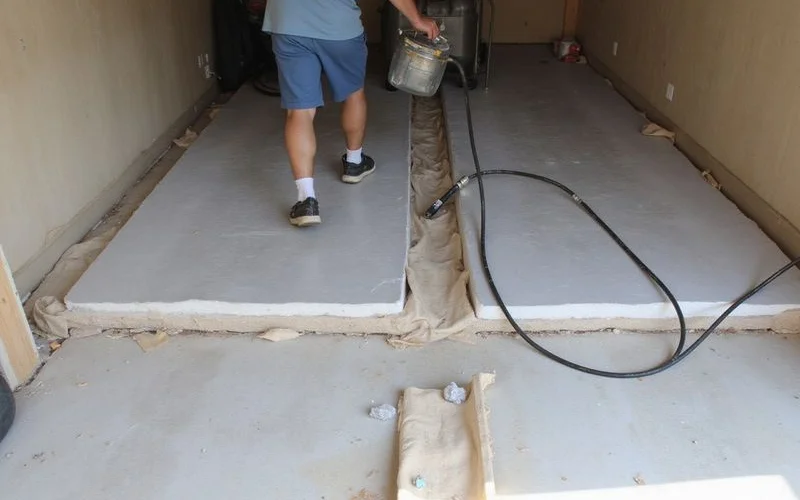 Foam injection bringing a heaved garage slab section back flush
